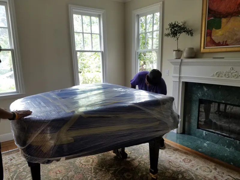 Professional piano movers carefully transporting a piano